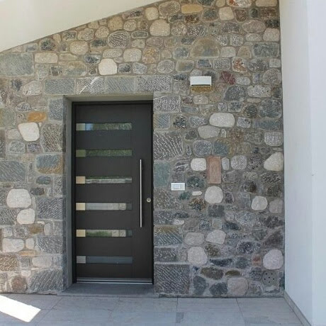 Porta moderna inserita in una facciata rivestita in pietra